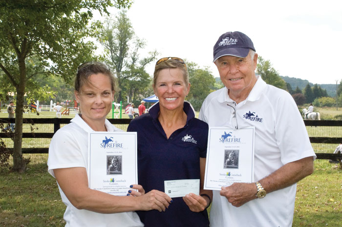 Christy Stauffer, Jan Byyny and Richard Byyny showing a check made out to the Stroke Comeback Center. 
