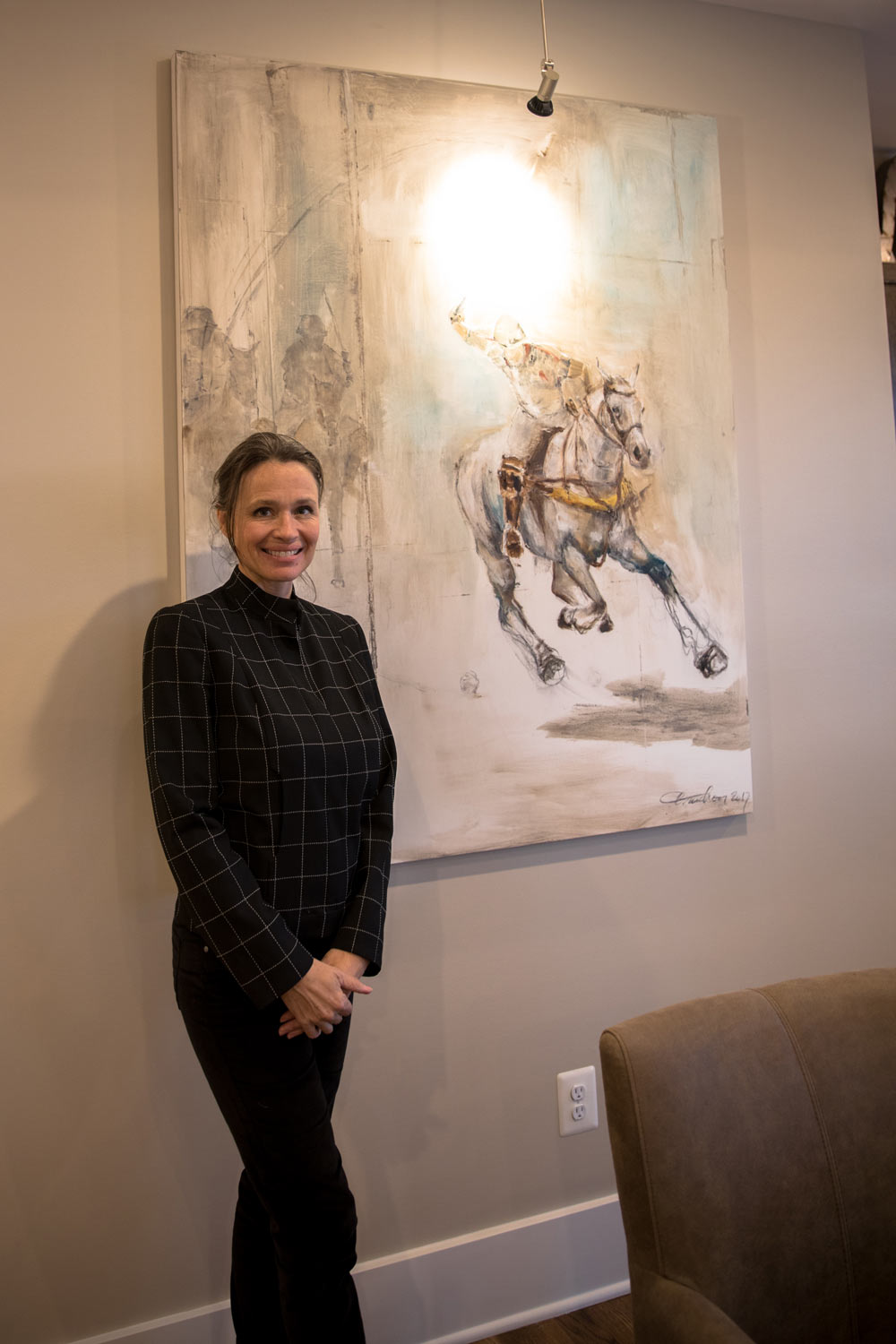 Local artist Isabelle Truchon next to one of many paintings she created for the tasting space.