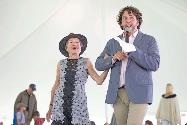 Ann MacLeod, mayor of Upperville, wearing Nanette Lepore from Tully Rector, stands with fashion show master of ceremonies Tom Sweitzer as the crowd sings "Happy Birthday" in celebration of her upcoming 95th birthday