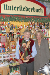 Dieter and Linda Rausch under a sign bearing the name of his hometown in Germany.