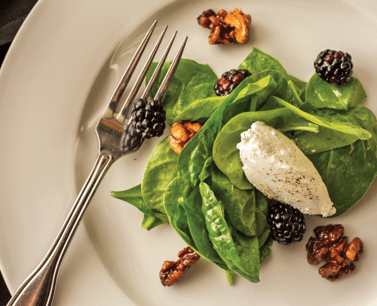 The second course is a spinach and blackberry salad with delicate champagne vinaigrette and candied walnuts, topped by a light and creamy peppered goat cheese